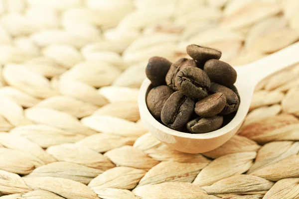 Kaffebönor i en träsked — Stockfoto