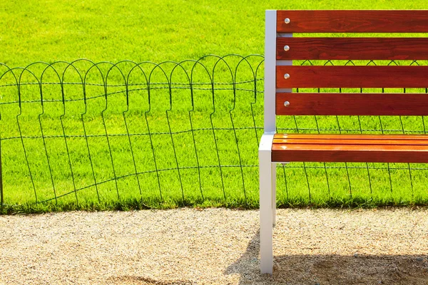 グリーン フィールドの背景に木製のベンチ — ストック写真