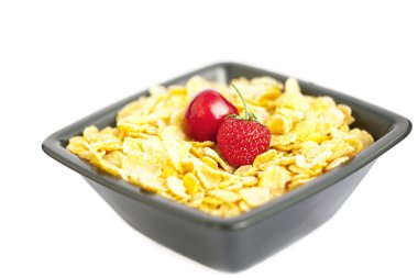 Bowl of cornflakes cherry and strawberry isolated on white