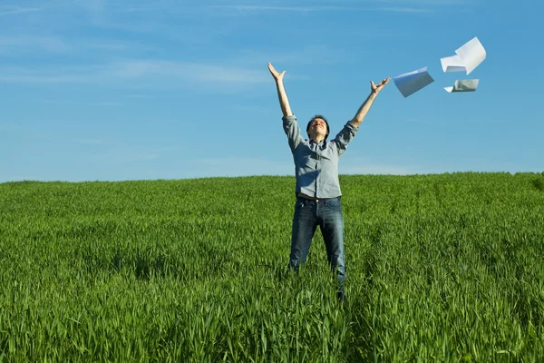 Man throws the paper in the field — Stock Photo, Image