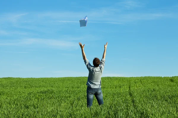 Man throws the paper in the field — Stock Photo, Image
