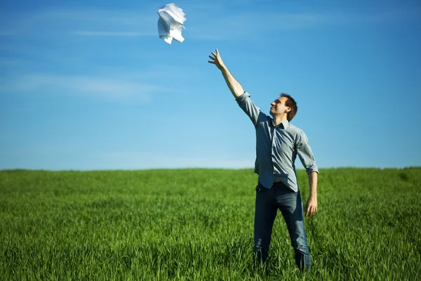 Człowiek rzuca papier w polu — Zdjęcie stockowe