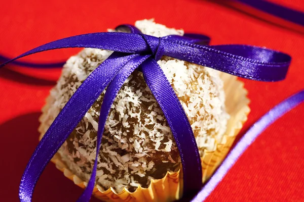 Torta condita con nastro di cocco fasciato su uno sfondo rosso — Foto Stock