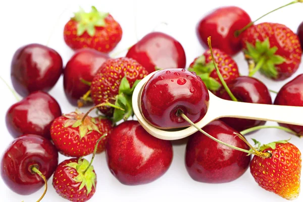 Cereza y fresa en una cuchara aislada en blanco —  Fotos de Stock