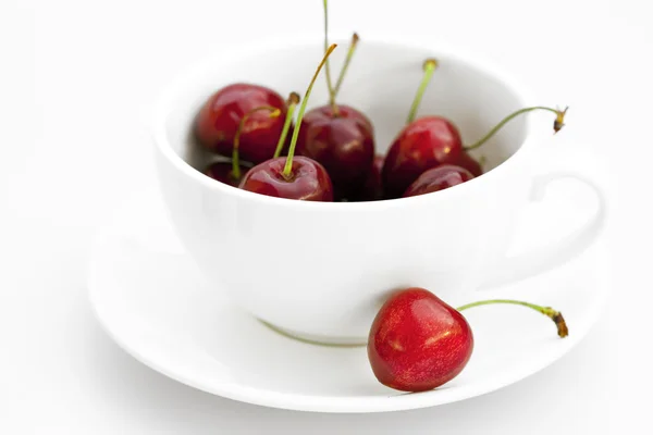 Cup saucer and cherries isolated on white — Stock Photo, Image
