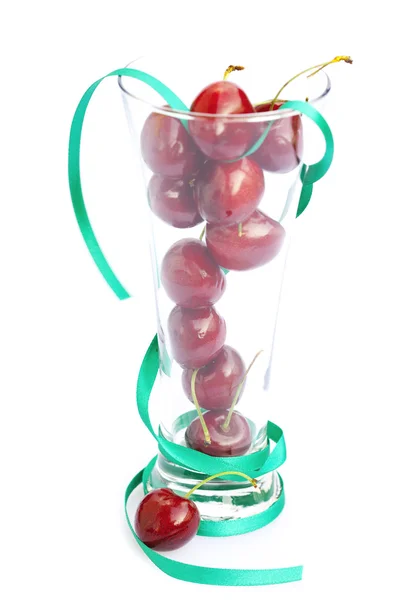 Cherry in a glass and ribbon isolated on white — Stock Photo, Image
