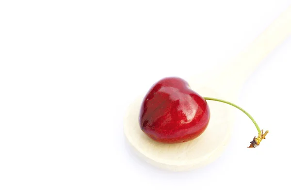 Egy fakanállal, elszigetelt fehér cseresznye — Stock Fotó