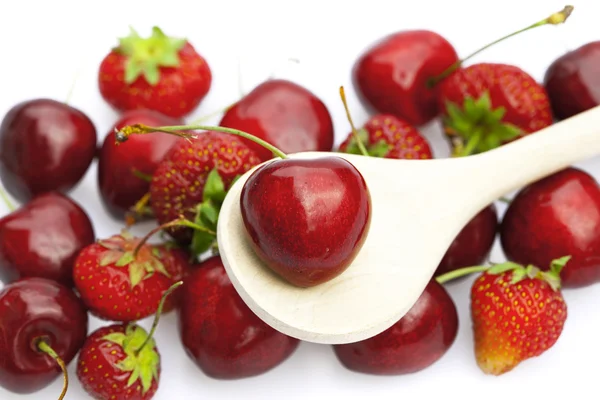 Kirsche und Erdbeere in einem Löffel isoliert auf weiß — Stockfoto