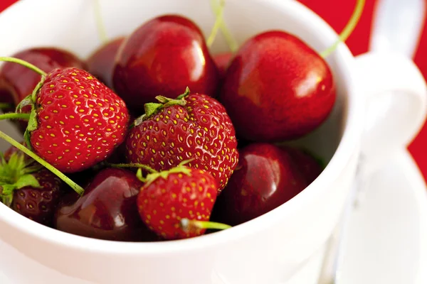 杯樱桃和草莓红色背景上 — 图库照片