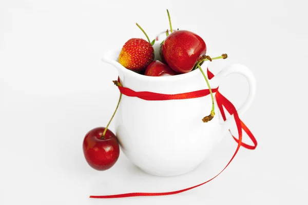 Lait jug ruban cerise et fraise isolé sur blanc — Photo