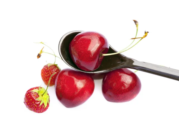 Cherry en aardbei in een lepel geïsoleerd op wit — Stockfoto
