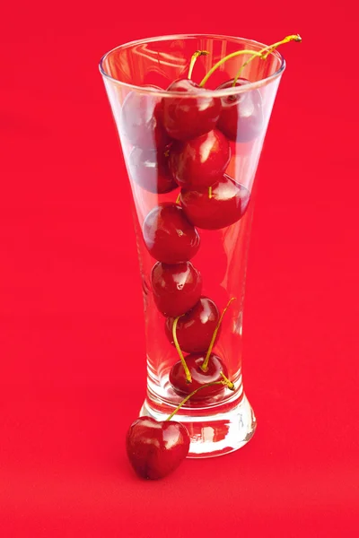 Bicchiere di ciliegia su sfondo rosso — Foto Stock