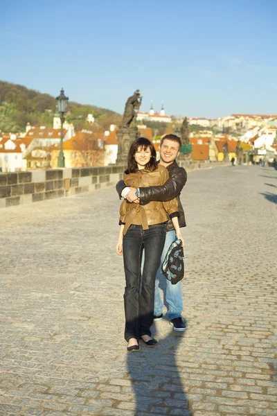 Mladý pár na Karlově mostě na obzoru — Stock fotografie
