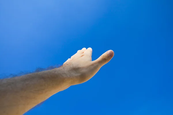 Рука на голубое небо — стоковое фото