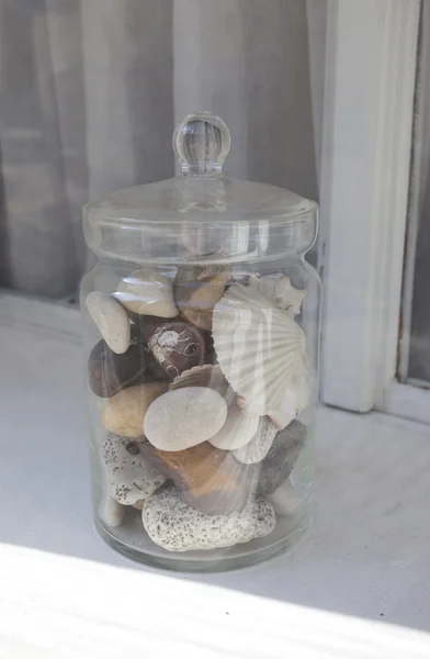 Bank av stenar och snäckor på fönsterbrädan — Stockfoto