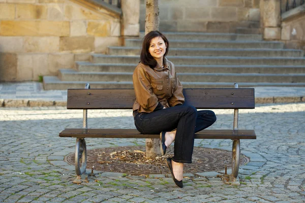 Belle jeune femme assise sur un banc — Photo