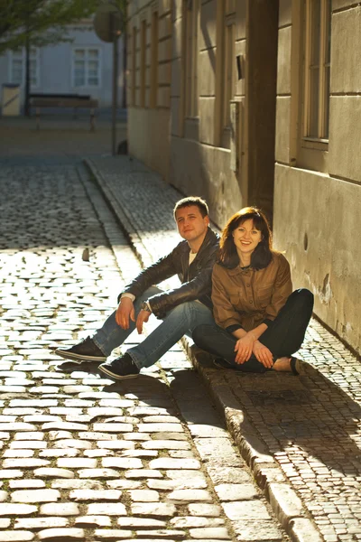 Любовная пара, сидящая на тротуаре — стоковое фото