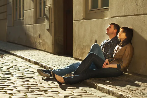 Любов пара сидить на тротуарі — стокове фото