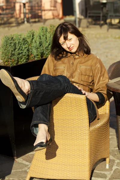 Όμορφη νεαρή γυναίκα που κάθεται σε μια ψάθινη καρέκλα — Φωτογραφία Αρχείου