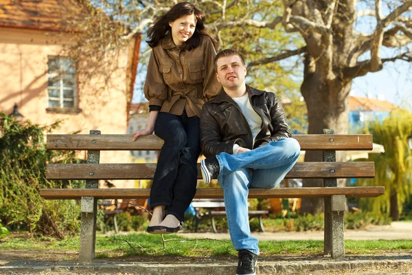 Влюбленная пара, сидящая на скамейке — стоковое фото