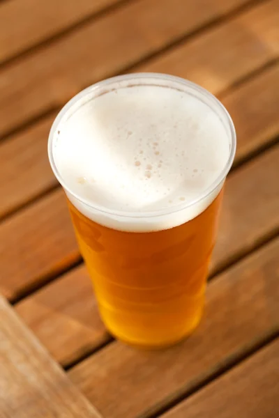 Cerveja em pé sobre uma mesa de madeira — Fotografia de Stock