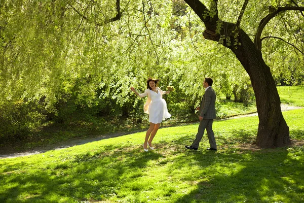 Acaba de casarse de pie bajo el árbol de madera verde —  Fotos de Stock