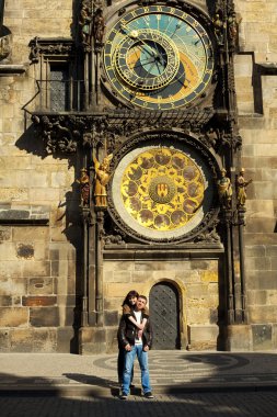 Young couple in love at Prague's astronomical clock clipart