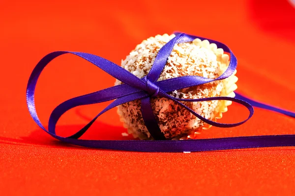 Biscoitos amarrados com uma fita em um fundo vermelho — Fotografia de Stock