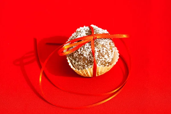 Biscoitos amarrados com uma fita em um fundo vermelho — Fotografia de Stock