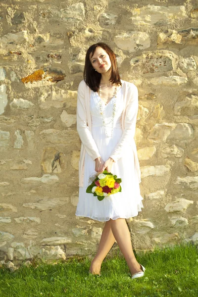 Giovane sposa in piedi al muro — Foto Stock