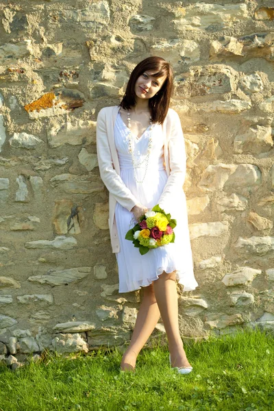 Mladá nevěsta stojící na zdi — Stock fotografie