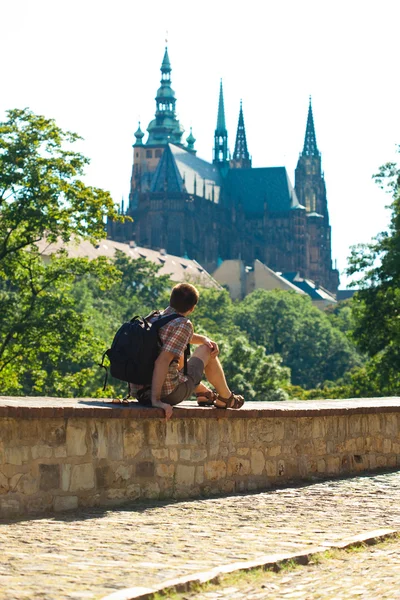 Мужчина, сидящий на фоне собора Святого Вита в Праге — стоковое фото