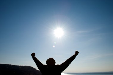 Man with his arms apart against the blue sky clipart