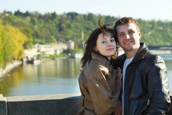 Pareja joven en un puente en el río — Foto de Stock