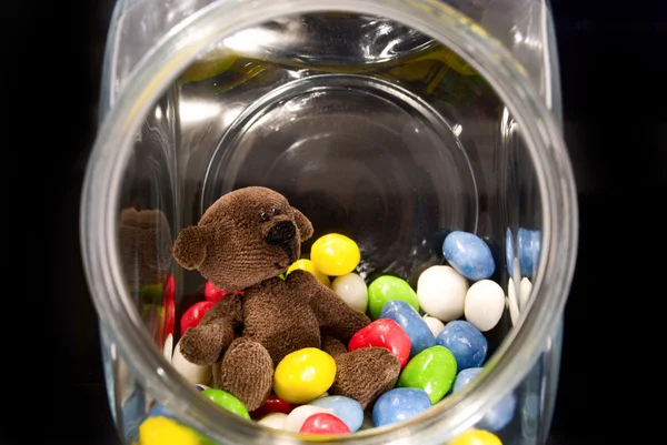 Teddy Bear and chocolates in a glass jar — Stock Photo, Image
