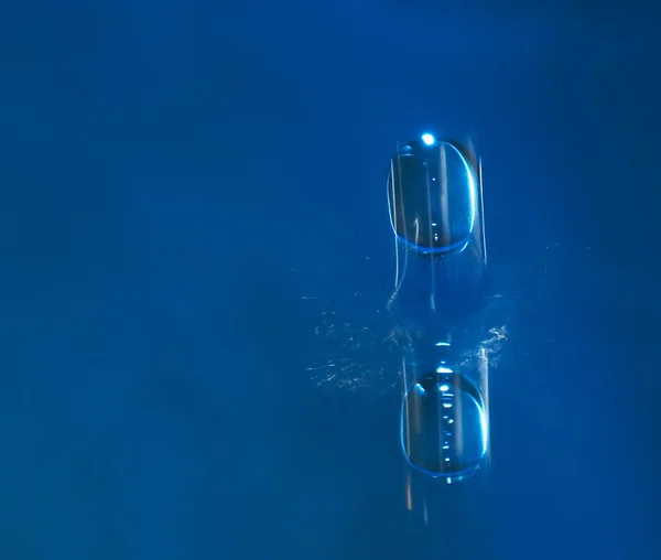 Una gota de agua sobre un fondo azul —  Fotos de Stock