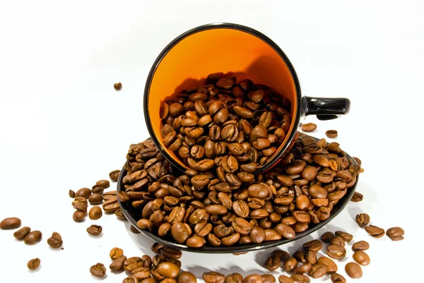 Taza y platillo con los granos de café aislados en blanco —  Fotos de Stock