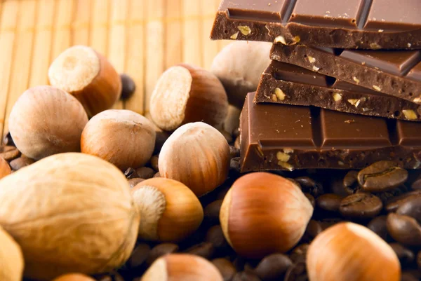 Chocolate and nuts on a bamboo mat — Stock Photo, Image