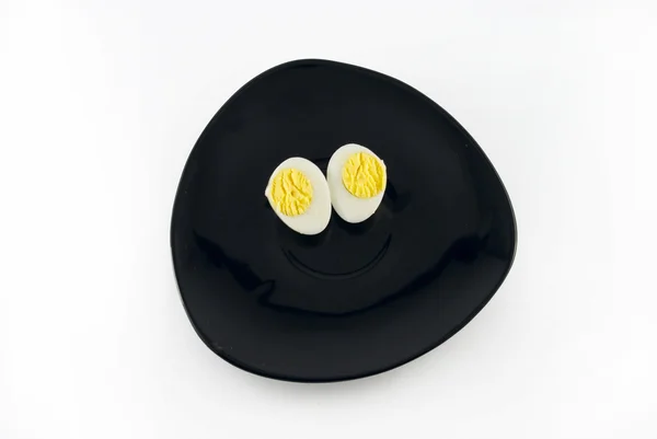 Quail egg on a black saucer isolated on white — Stockfoto