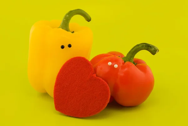 Stock image Peppers with eyes and heart on a green background