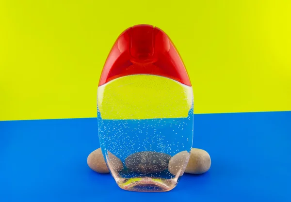 Cosmetische container en stenen op een kleurrijke achtergrond — Stockfoto