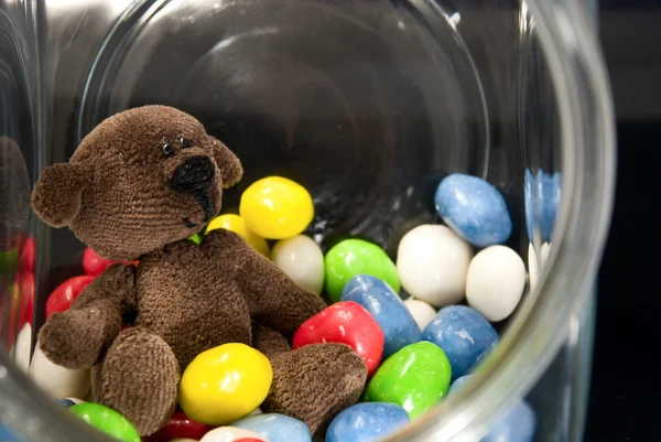 Teddy Bear and chocolates in a glass jar — Stock Photo, Image