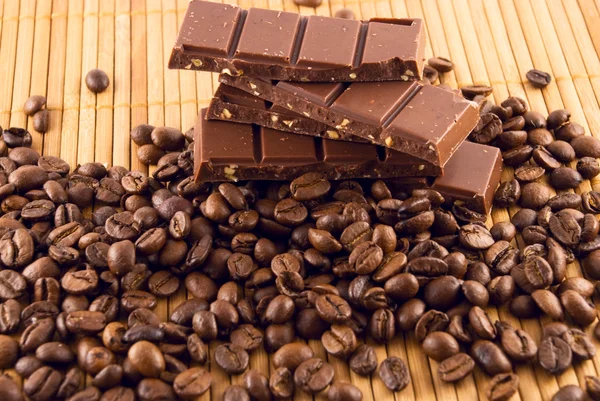 Chocolate and coffee beans on a bamboo mat — Stock Photo, Image