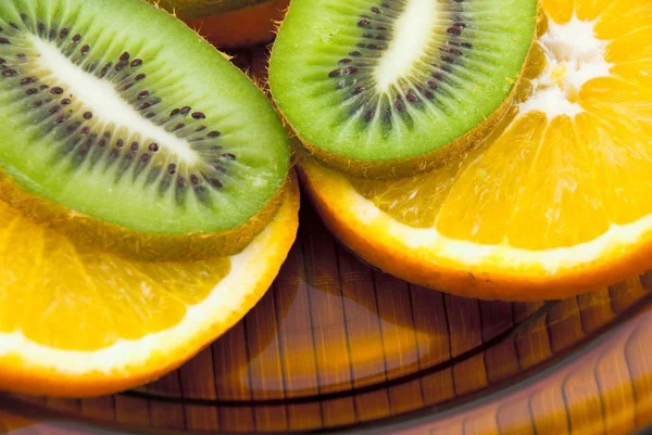 Kiwi groenten en sinaasappelen op een plaat — Stockfoto