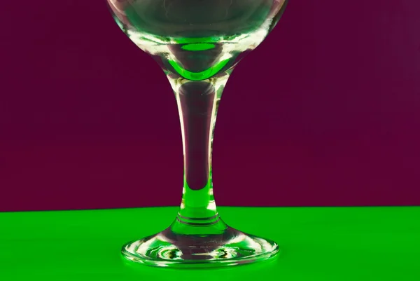 Begreppsmässigt upplysta vinglas mot en flerfärgad bakgrund — Stockfoto