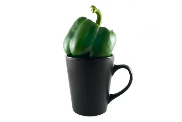 Pimentas verdes em uma xícara preta isolada em branco — Fotografia de Stock