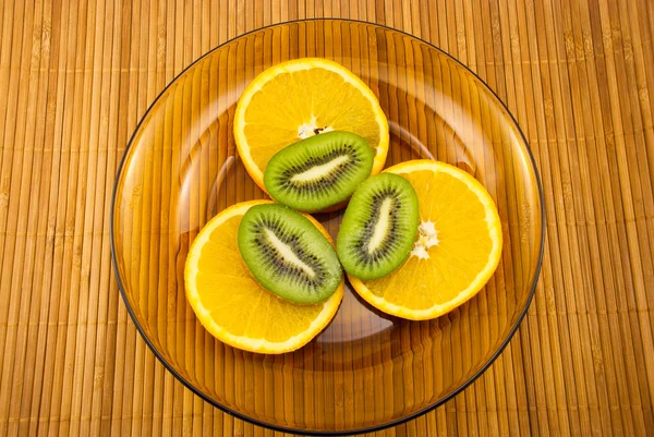 ผลไม้กีวีและส้มบนจาน — ภาพถ่ายสต็อก