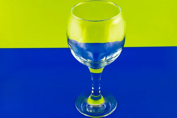 Copa de vino conceptualmente iluminada sobre un fondo multicolor — Foto de Stock