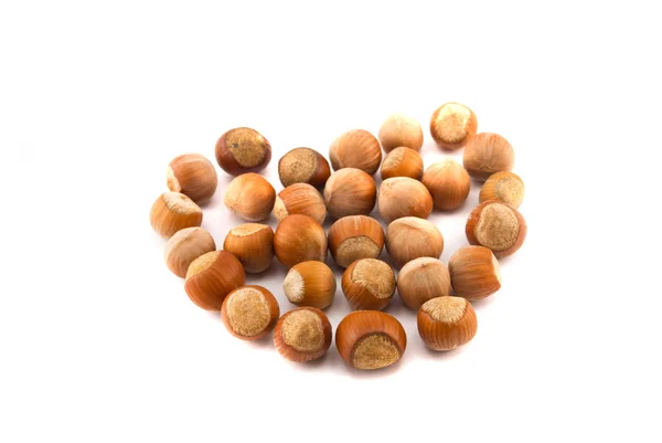 Hazelnuts in the shape of a heart isolated on white — Stock Photo, Image