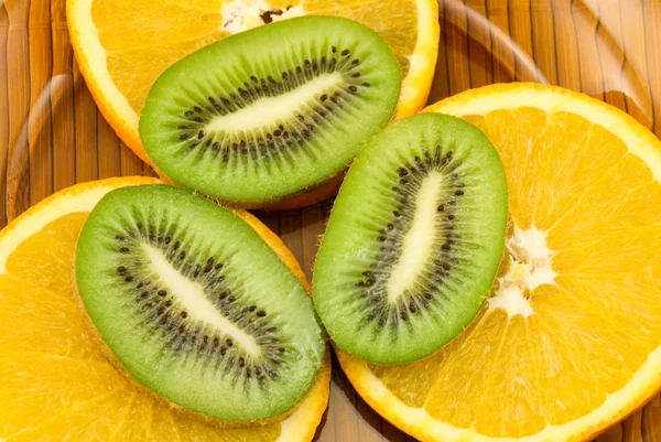 Apelsiner och kiwifrukt på en tallrik — Stockfoto